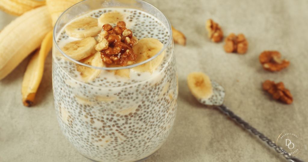 Chia banana smoothie in a mason jar surrounded by chia seeds.