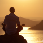 A silhouette of a person stretching or meditating outdoors at dawn, with a peaceful sunrise and natural landscape in the background, symbolizing renewal and mindfulness.