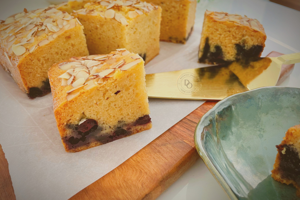 Slices of eggless blueberry almond cake topped with sliced almonds showing blueberries inside the cake