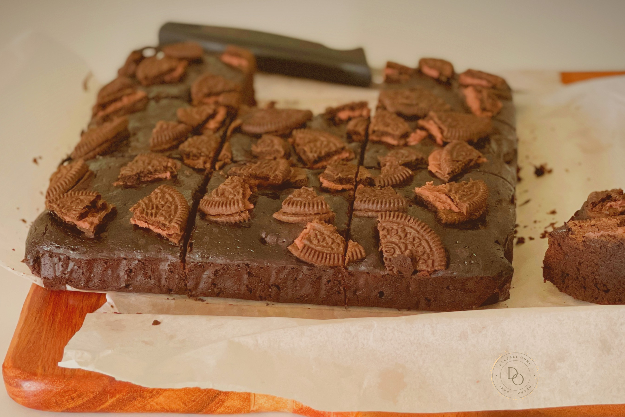 Eggless Oreo brownie slab cut into squares and topped with crushed Oreo cookies