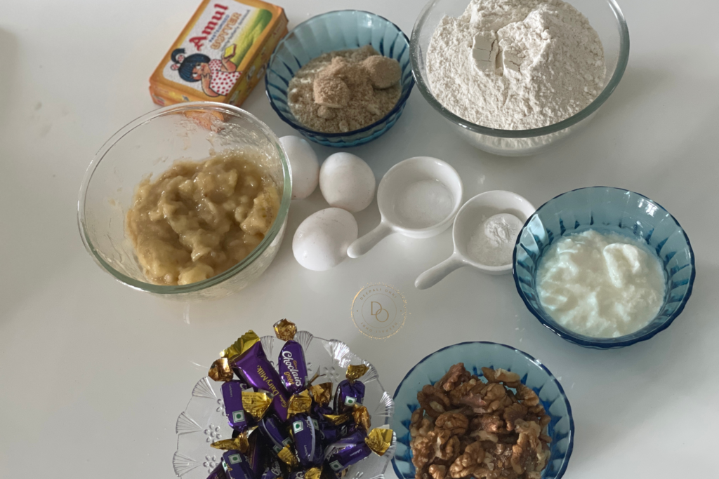 Ingredients for banana streusel bread including mashed bananas, flour, eggs, yogurt, butter, brown sugar, walnuts and caramel toffees