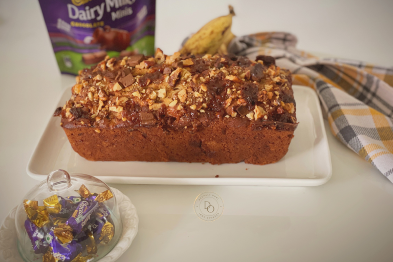 Banana streusel bread topped with walnuts, caramel toffees and chocolate chunks on a white plate