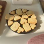 Three ingredient butter cookies arranged on a white plate, some broken in half to show crispy texture