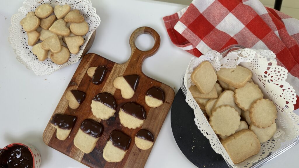 Three ingredient eggless butter cookies with chocolate dipped variation on a wooden board, served with plain cookies on a doily lined plate