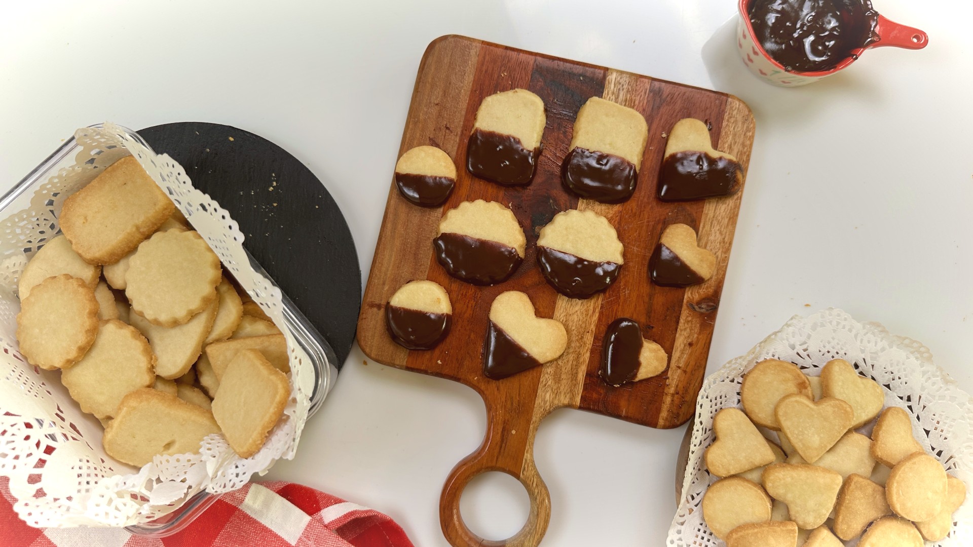 Three ingredient eggless butter cookies with chocolate dipped variation on a wooden board, served with plain cookies on a doily lined plate
