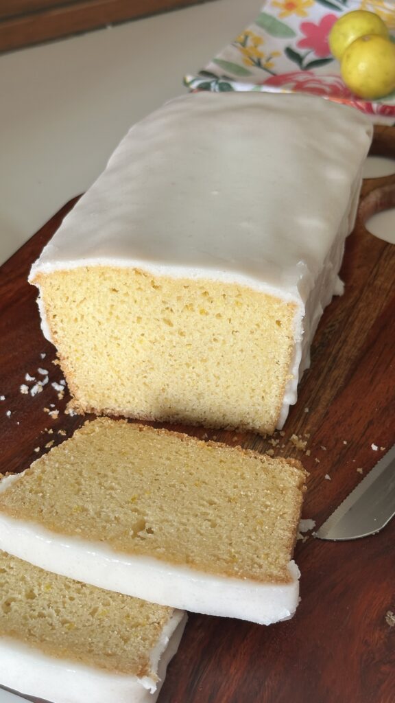 Close-up of sliced Mary Berry lemon drizzle cake showing soft moist crumb with icing glaze on top