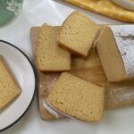 Overhead view of condensed milk cake slices on a wooden board with powdered sugar dusting