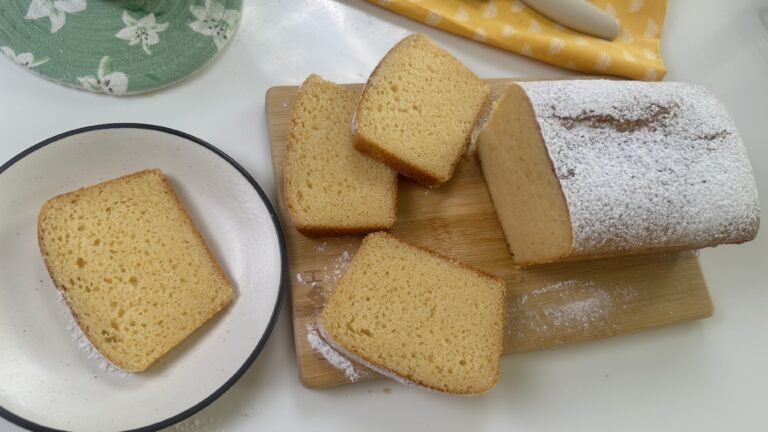 Overhead view of condensed milk cake slices on a wooden board with powdered sugar dusting