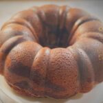 Whole red velvet marble cake dusted with powdered sugar in a bundt shape