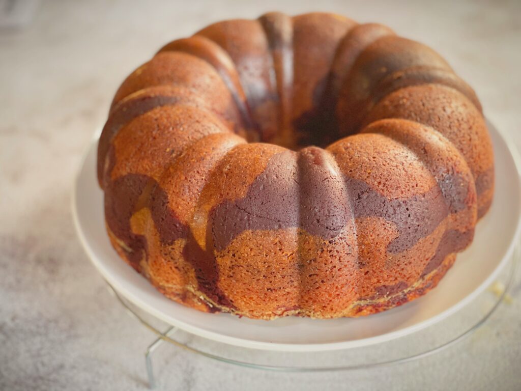 Top-down view of unsliced red velvet marble bundt cake with visible red swirls through the ridges