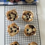 Blueberry Chocolate Muffins on a wire cooling rack with hydrangea flowers by Deepali Ohri