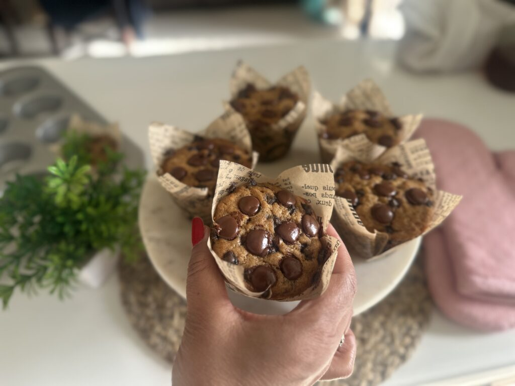 close up of eggless chocolate chip banana muffin with glossy dark chocolate chips on top
