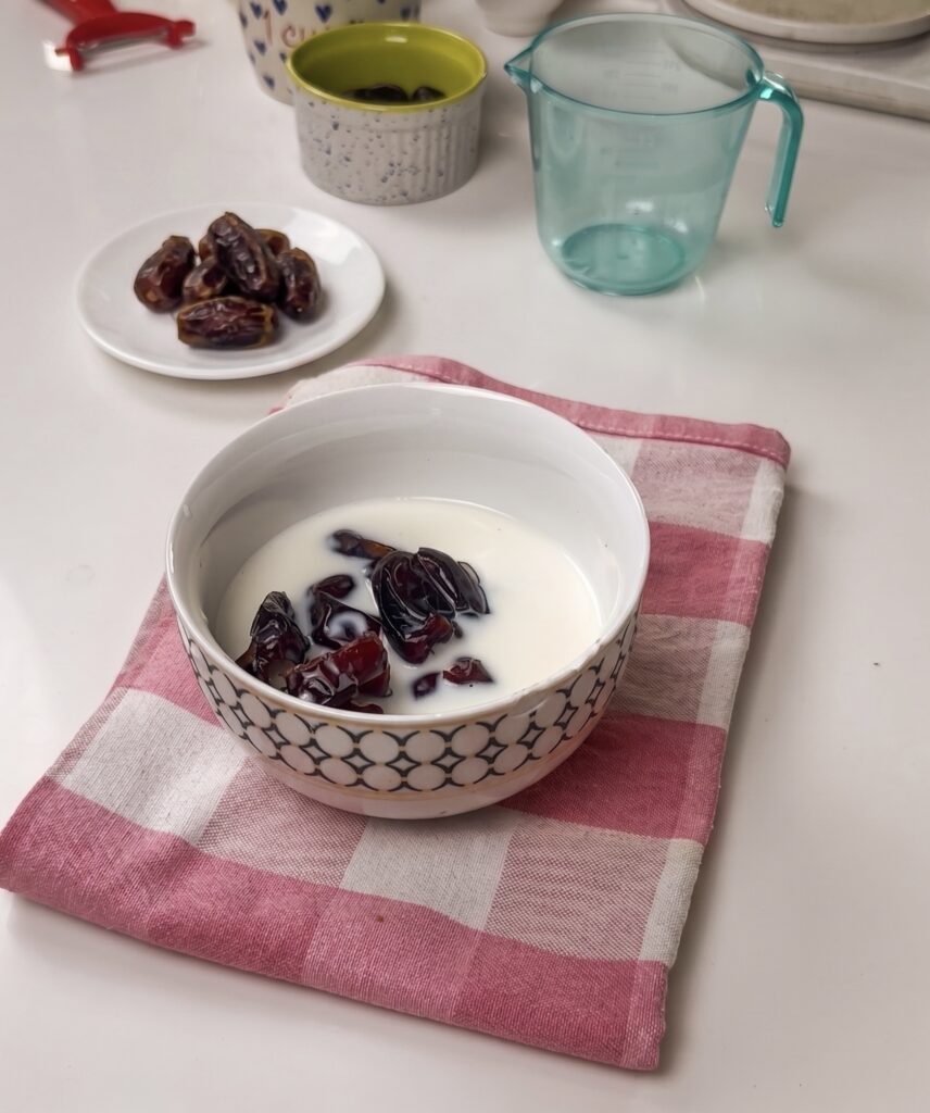 Chopped dates soaking in warm milk for Eggless Date & Carrot Cake