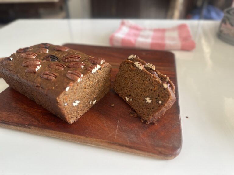 Eggless Dates & Carrot Cake Eggless Date & Carrot Cake whole loaf with slice on a wooden board