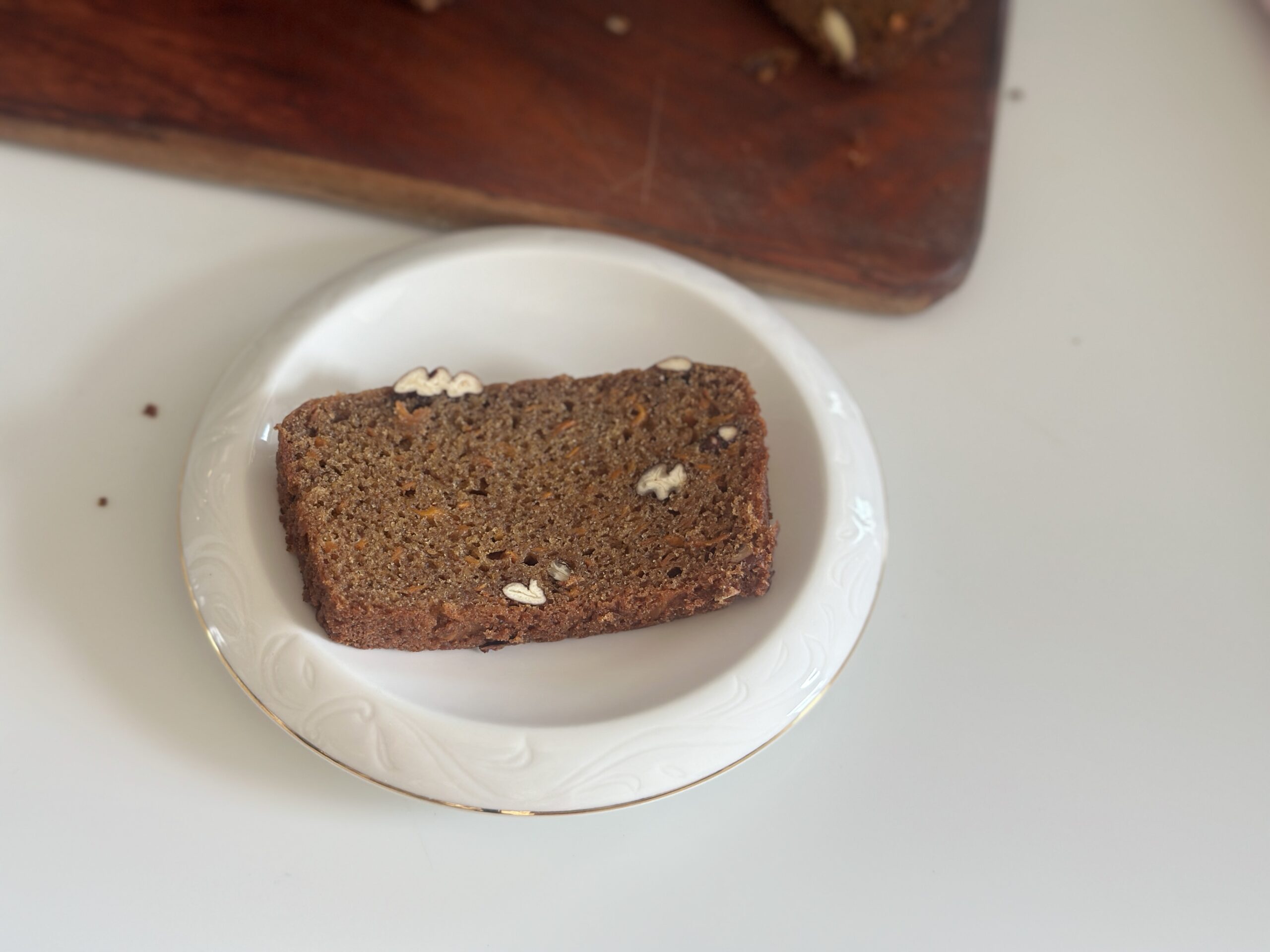 A single slice of Eggless Date & Carrot Cake on a white plate