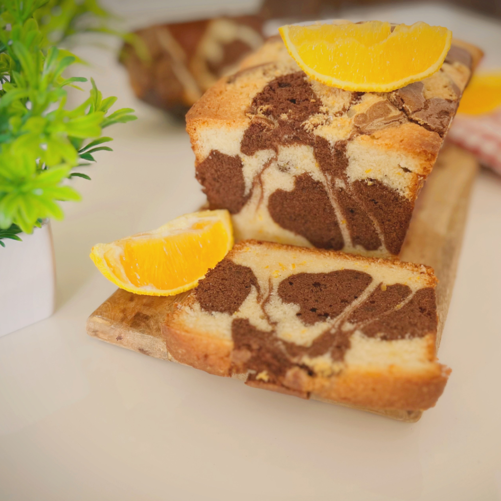 Close-up slice of chocolate orange marble cake with orange wedge garnish