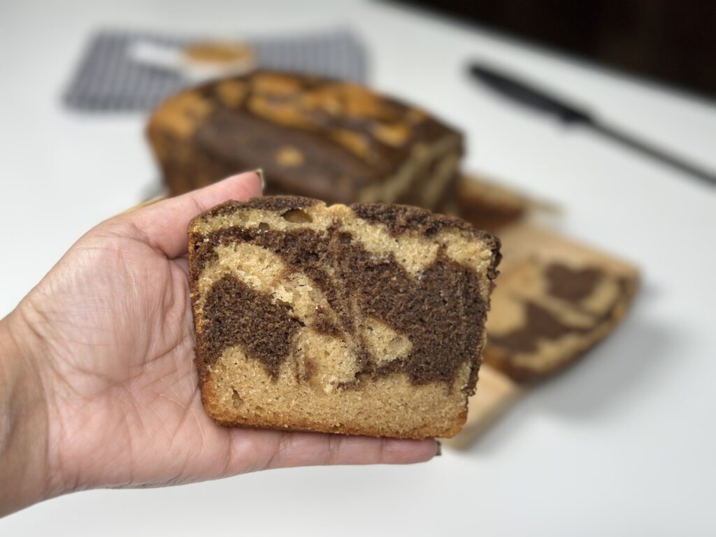 Close-up of eggless peanut butter marble loaf cake crumb held in hand