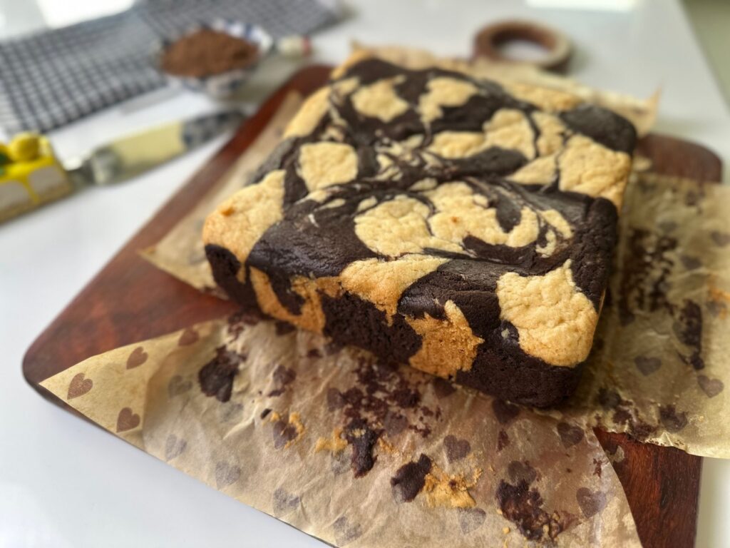 Baked eggless marble cake with a flat golden top and chocolate swirls on parchment