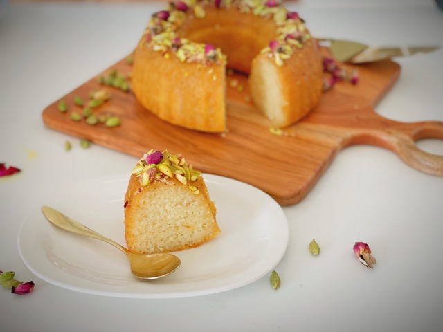 Slice of soft eggless gulab jamun cake on a white plate