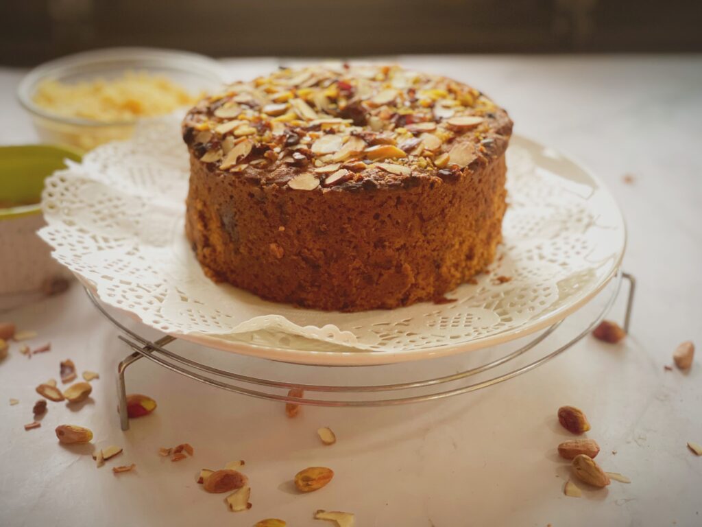 Tall eggless mawa cake baked in a 6-inch tin on a cake stand