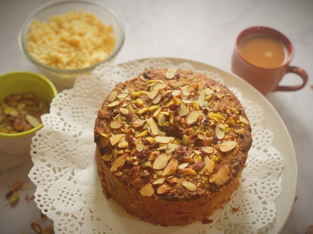 Top of an eggless mawa cake covered in almond and pistachio slivers