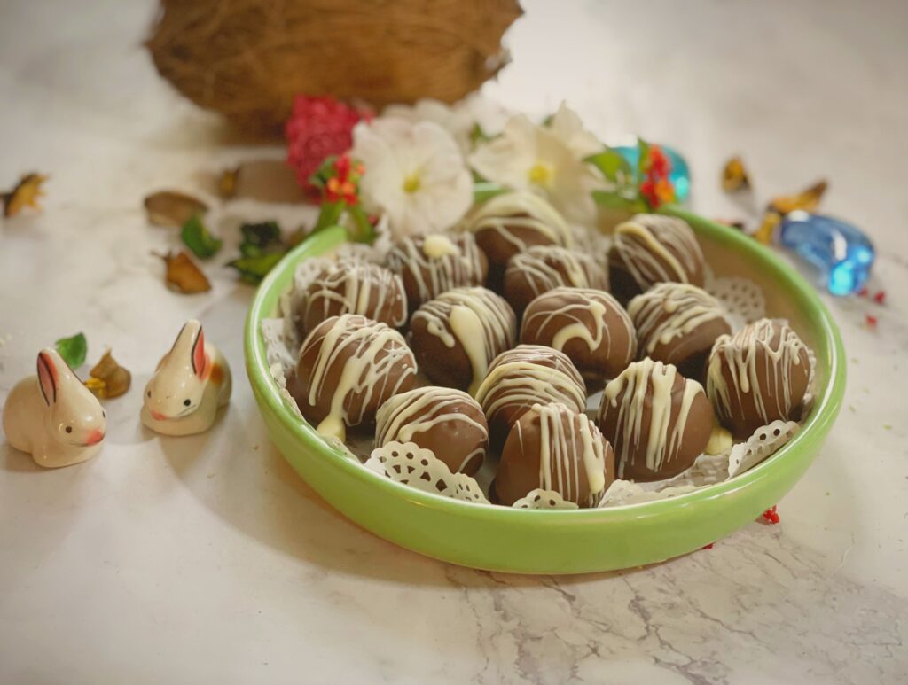 Green bowl full of homemade chocolate coconut balls