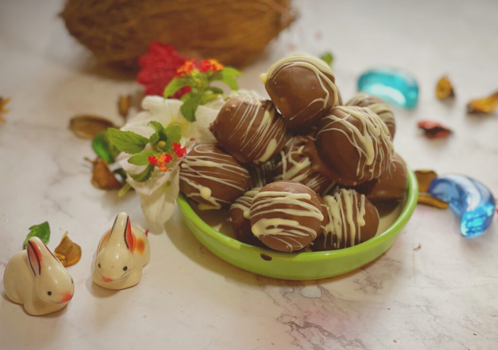 A pile of chocolate coconut balls in a green bowl