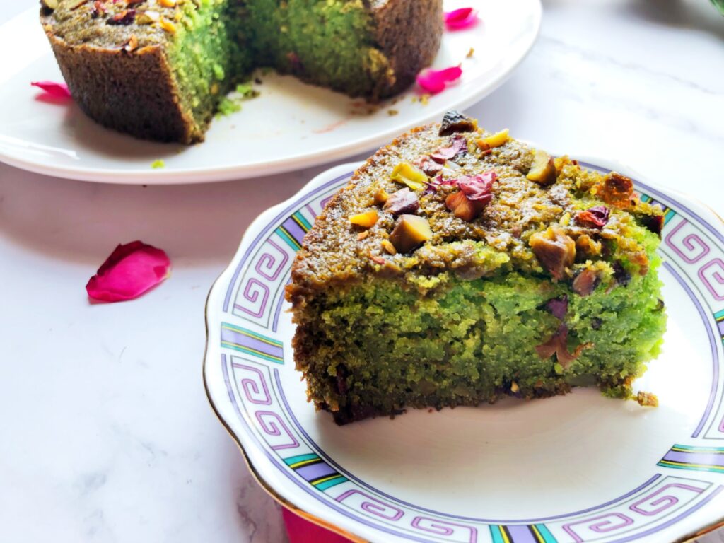 Slice of soft green eggless paan cake on a plate