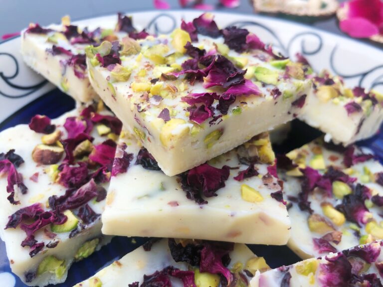 Close-up of rose pistachio white chocolate fudge squares topped with dried rose petals and pistachios