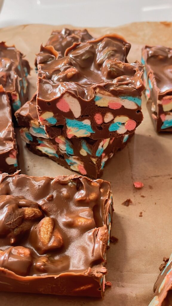 Chocolate marshmallow squares cut and stacked on parchment paper