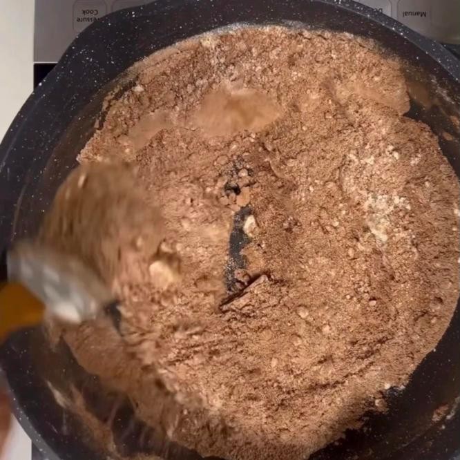 Milk powder and cocoa being roasted together in a pan for chocolate peda